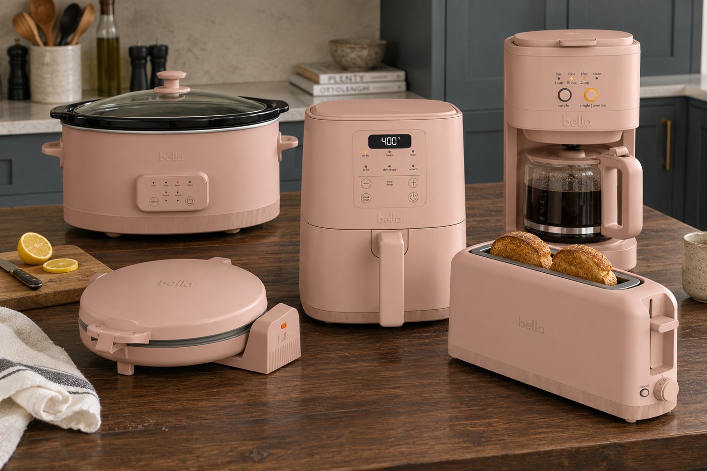 Styling visualization of five bella Blossom pink appliances on a walnut kitchen island, without the griddle.