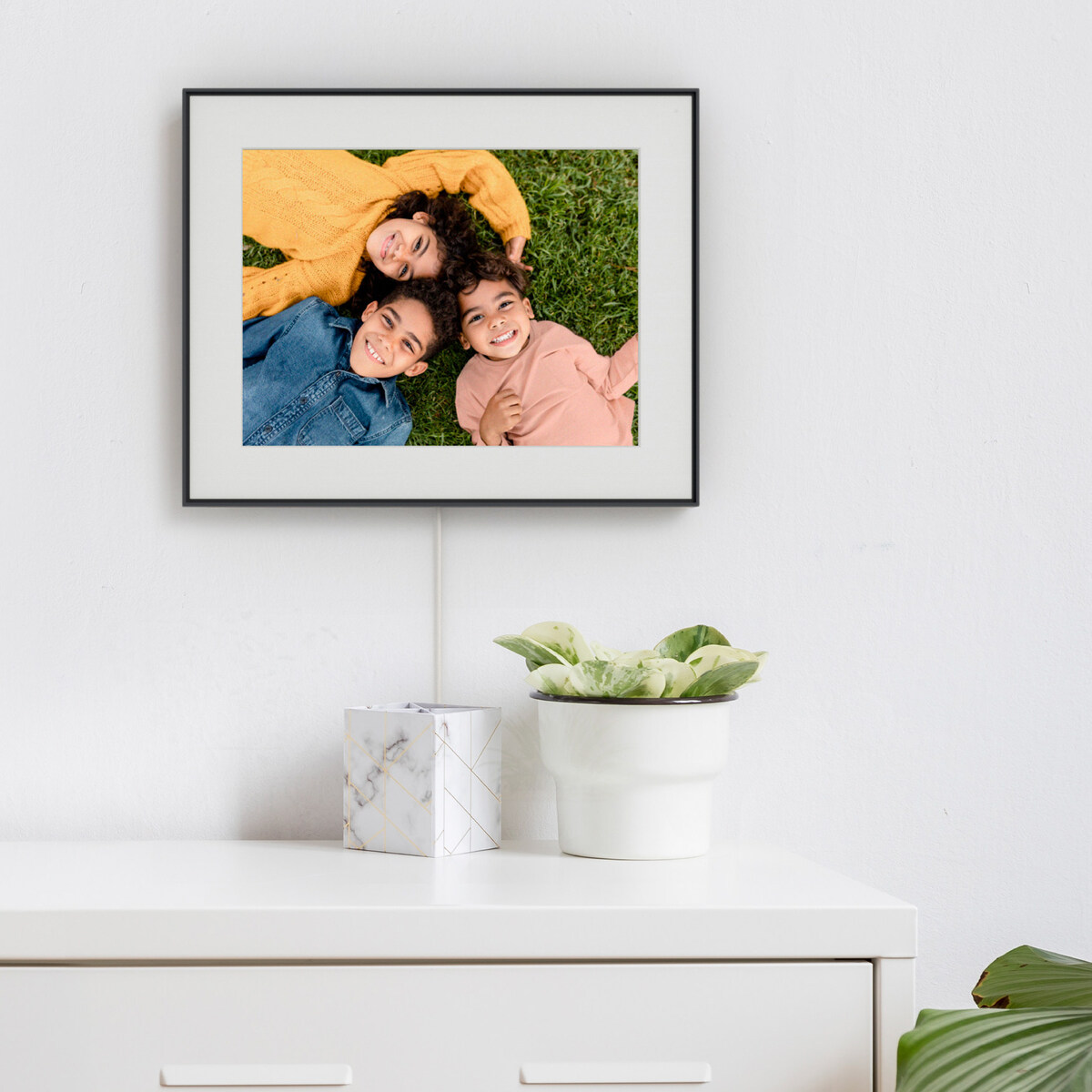 Aura Walden in Ink with a light mat mounted above a dresser, with its power cable visible