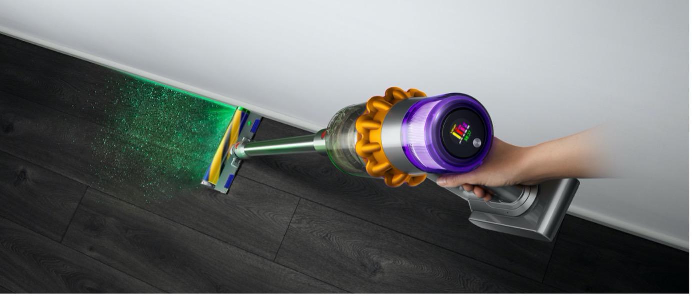 Yellow and purple Dyson V15 Detect cleaning beside a baseboard in Dyson’s launch photograph