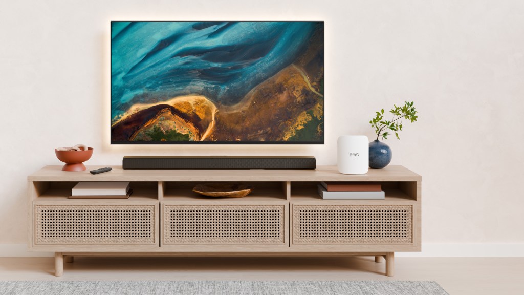 White eero Pro 7 router beside a television on a wood media console